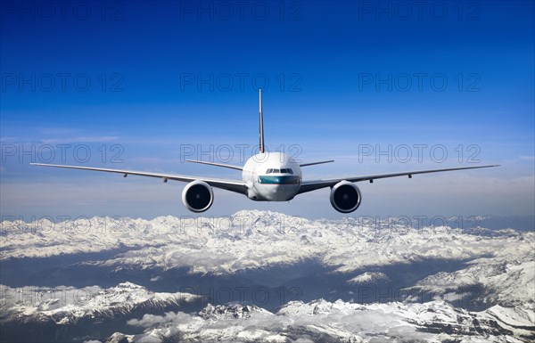 Cathay Pacific Boeing 777-367 ER in flight over mountains