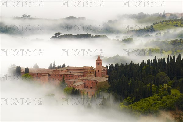 Monte Oliveto Maggiore abbey with mist-shrouded valleys