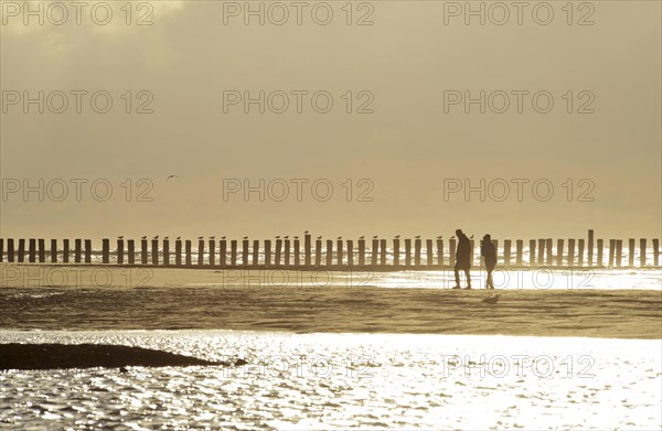 Couple walking in front of groynes