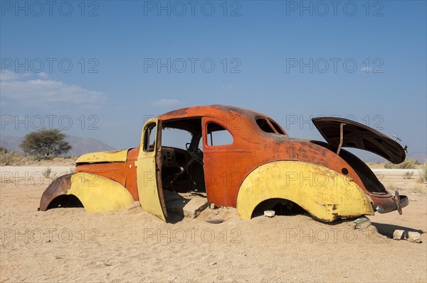 Old car wreck stuck in the sand