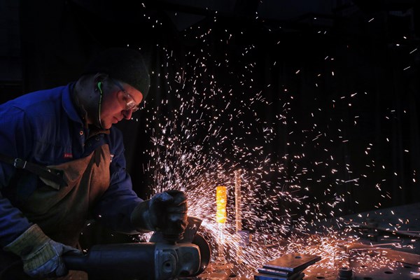 Man grinding a piece of iron