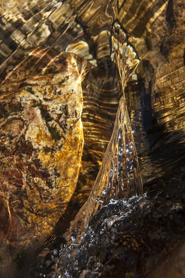 Closeup of a water stream flowing over a rock