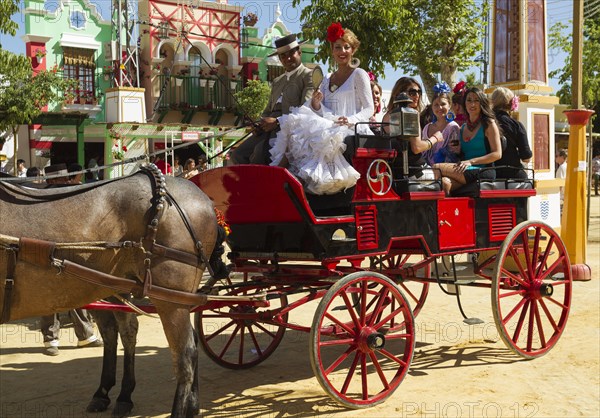 Dressed up coachman and young ladies wearing gypsy dresses at the Feria del Caballo Horse Fair