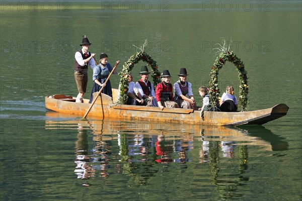 Locals wearing traditional costumes in a decorated wooden Platte boat