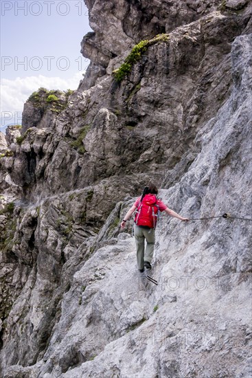 Female hiker walking along the fixed cable route of Jubilaeumssteig