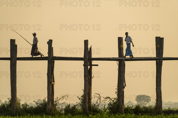 Locals walking on a teak bridge