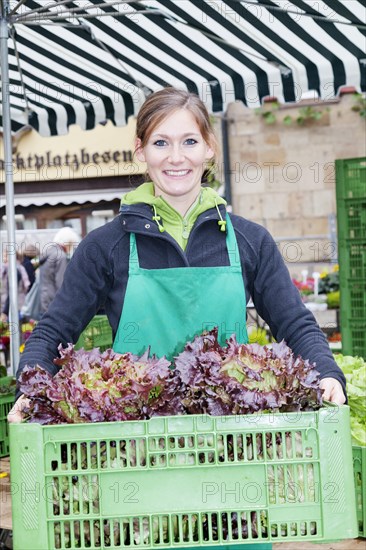 Woman holding a crate of salad