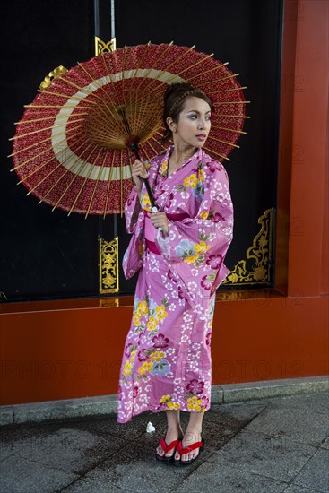 Young woman in kimono and with oil-paper umbrella