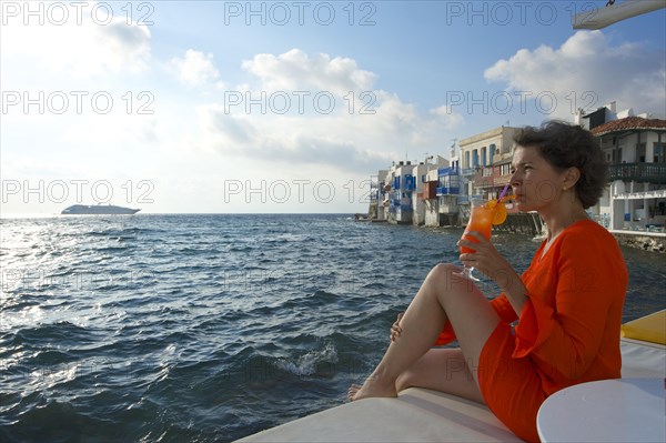 Woman enjoying a cocktail and a view over the sea