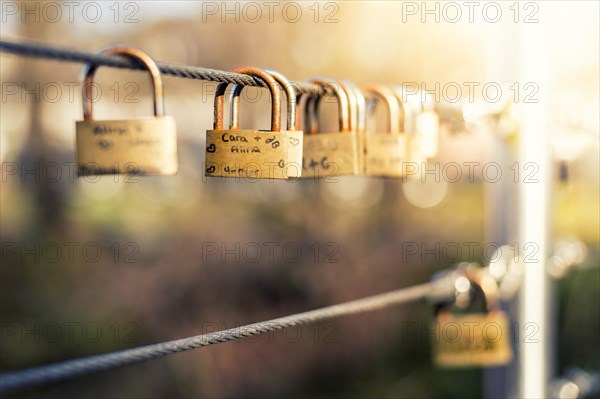 Padlocks as love locks hanging next to each other on a bridge railing