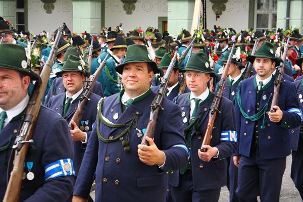 Members of a Bavarian shooting club at a costume parade with shouldered rifles