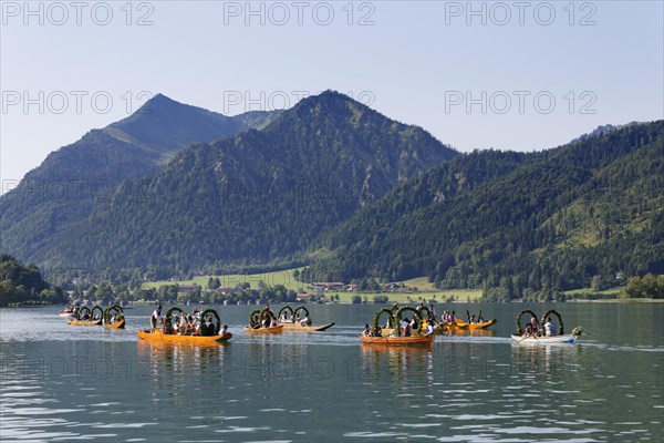 Locals wearing traditional costumes in decorated wooden Platte boats