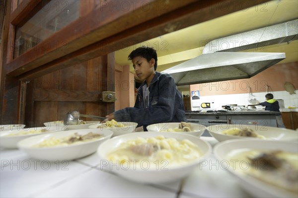 Boy working at the food counter in the kitchen of a children's home