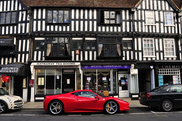 Ferrari car parked in front of a half-timbered house