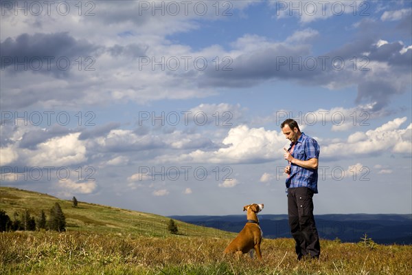 Man making his dog 'sit'