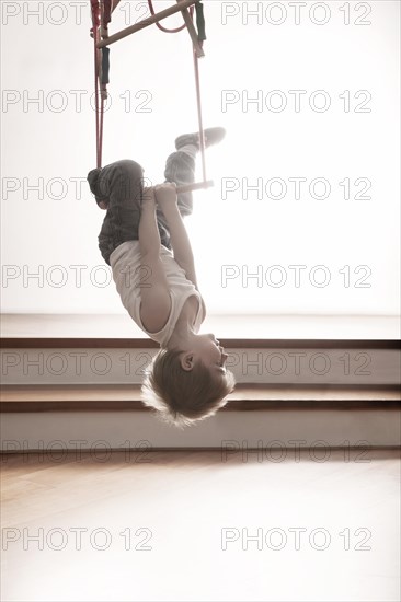Young boy exercising on a swing