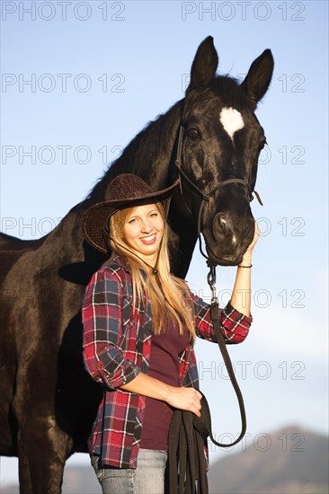 Young woman with a black Hanoverian horse