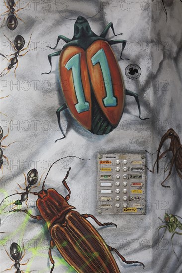 Doorbells on a facade painted with beetles