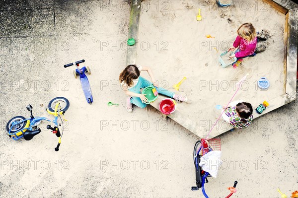 Children playing in the sandbox of a backyard