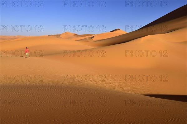 Woman walking in the dunes of In Tehak