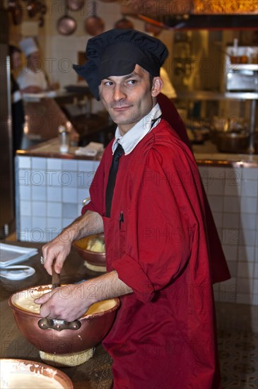 Chef preparing the traditional omelette mixture in copper bowls