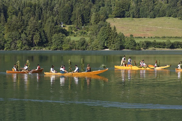 Locals wearing traditional costumes in decorated wooden Platte boats