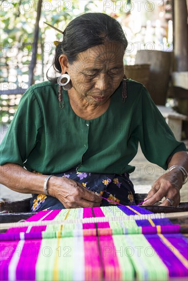 Woman with traditional facial tattoos and ear jewellery from the Chin people