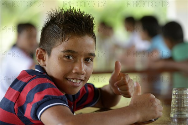 Brazilian boy signaling OK with his thumbs up