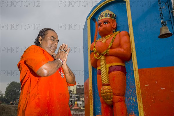 A devotee is praying in front of a Hanuman statue