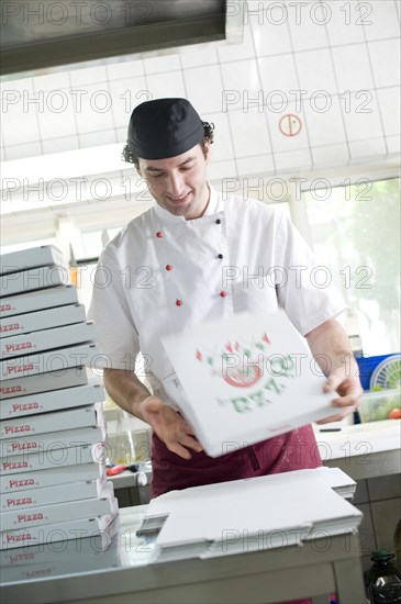 Pizza baker folding a pizza box