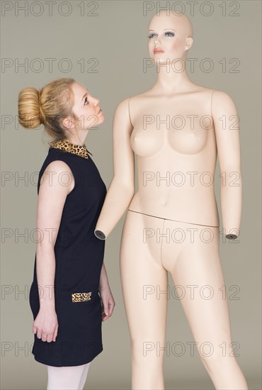 Young woman looking at naked female mannequin
