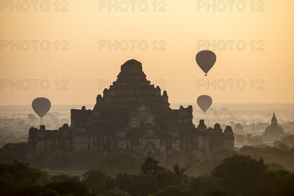 Hot air balloons over the landscape in the early morning fog