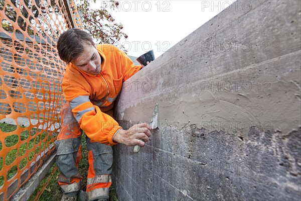 Man doing concrete restoration and construction work on the main building of the HSG University of St. Gallen