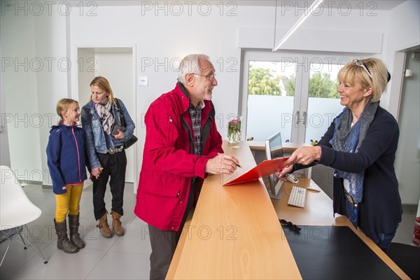 Patient filling in a form at the reception of a dental office