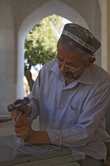 Stonemason chiselling a grave stone