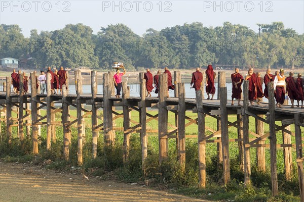 Locals and monks on a teak bridge