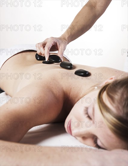 Young woman being treated with hot stones