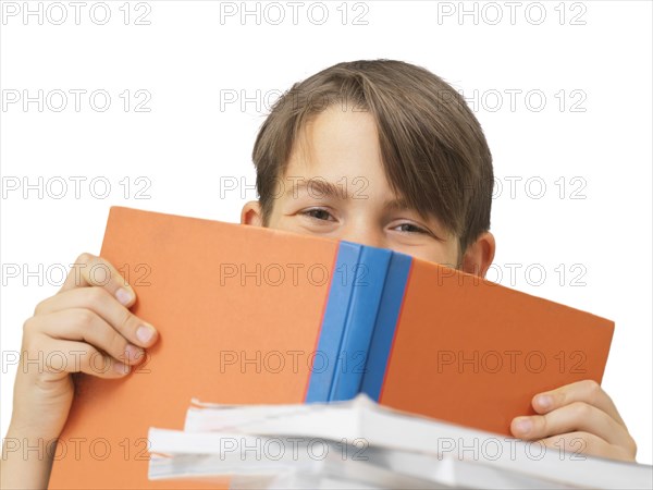 Schoolboy behind a school book