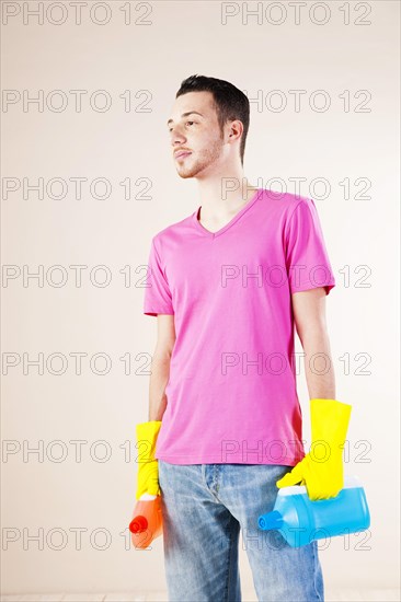 Man holding bottles of cleaning agents in his hands