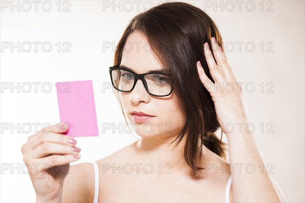 Young woman looking at herself in a cosmetic mirror