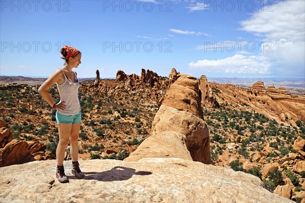 Hiker standing on Double O Arch with a view over Devil's Garden