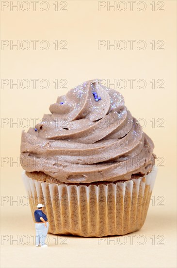 Miniature figurine standing in front of muffin