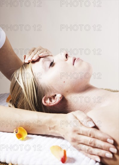 Young woman being treated by a therapist on her head and upper torso