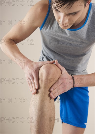 Young man examining his knee