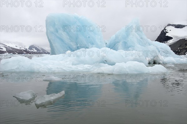 Iceberg reflections on cloudy day in the waters of Samarinvagen Bay in Hornsund