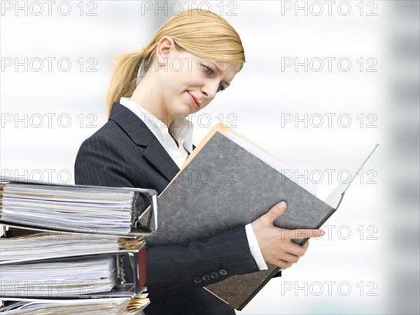 Young business woman reading in a folder