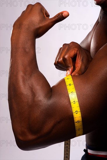 Man measuring his biceps with a tape measure