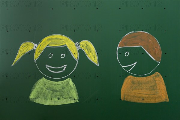 Two children drawn with chalk on a blackboard