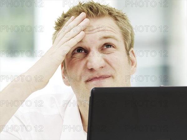 Businessman holding a hand on his wrinkled forehead