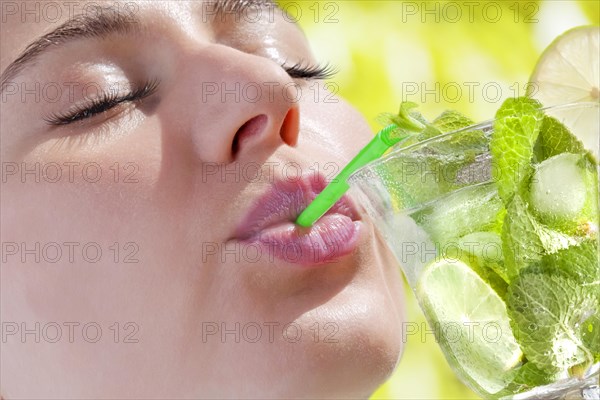 Woman drinking a Hugo cocktail with lime and mint